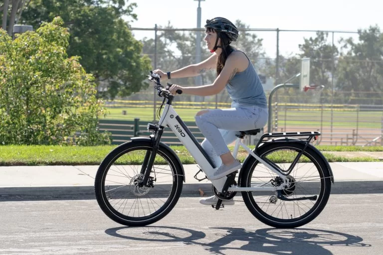 a woman riding an e-bike on the road