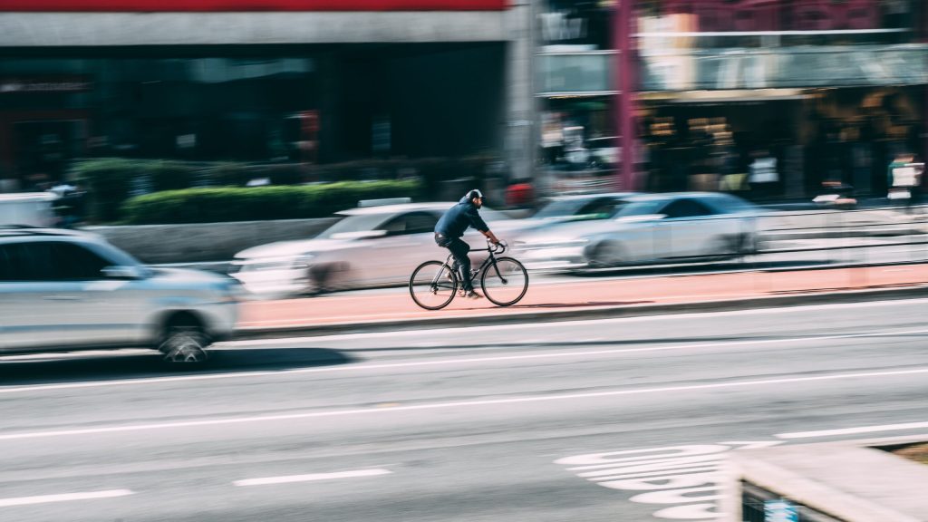 man riding e-bike in the middle of city