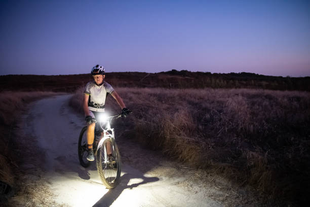 Night MTB Rider With A Light At Sunset