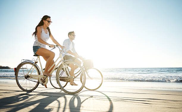 Full length shot of a young couple cycling on the beach