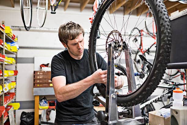 man cleaning e-bike brake rotors