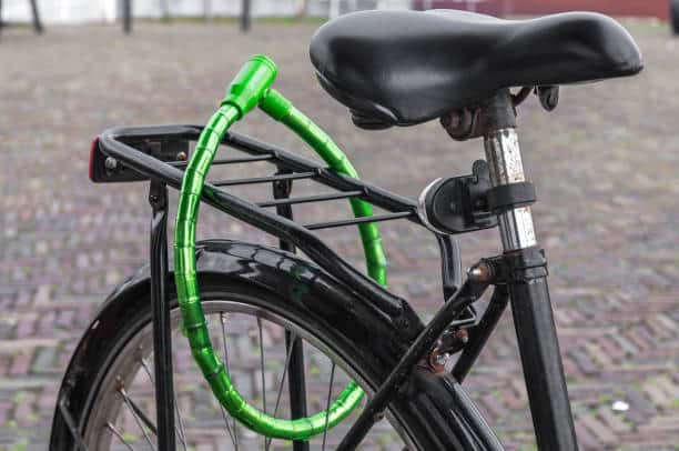 black Dutch ladies bike locked with a green padlock