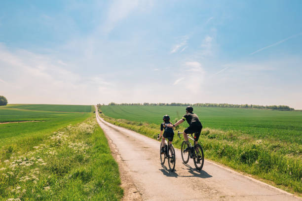picture showing 2 people with a long road ahead of them riding an ebike