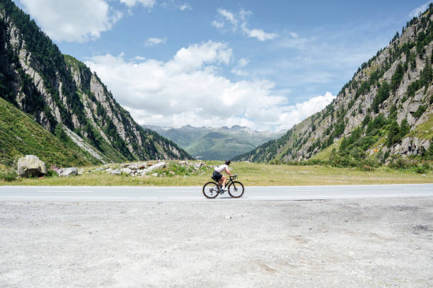 Cyclist enjoying a ride on a scenic mountain road, surrounded by stunning alpine landscapes