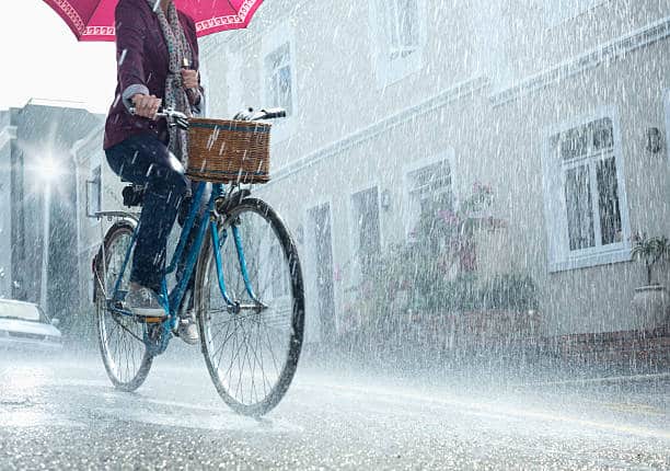man riding bike in rain